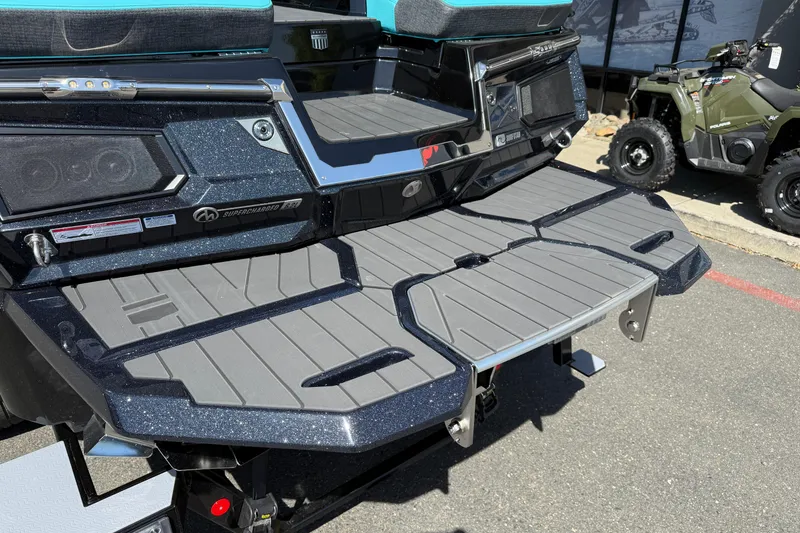 Slide: The Image of 2026 MasterCraft X24 boat rear deck with speakers and seating, displayed outdoors. - 12