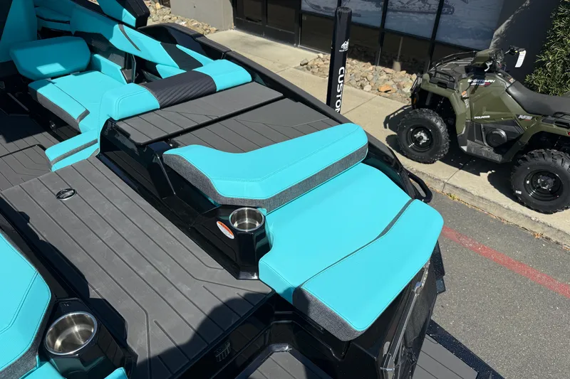 Slide: The Image of 2026 MasterCraft X24 boat interior with turquoise seating and cup holders. - 18