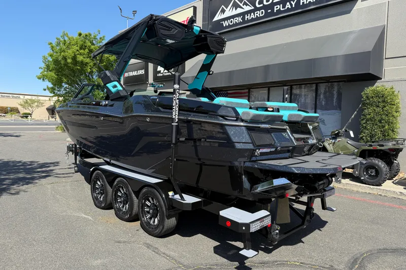 Slide: The Image of 2026 MasterCraft X24 boat on a trailer, parked outside a dealership. - 2