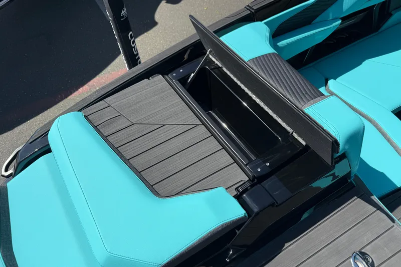 Slide: The Image of 2026 MasterCraft X24 boat interior with teal seating and storage compartment. - 22