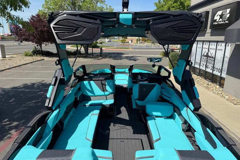 Slide: The Image of 2026 MasterCraft X24 boat with turquoise interior, parked outdoors. - 23