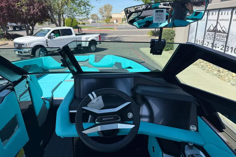 Slide: The Image of Interior view of 2026 MasterCraft X24 boat with turquoise seating and modern dashboard. - 25