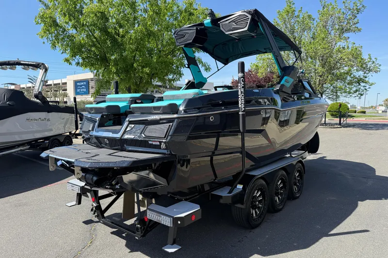 Slide: The Image of 2026 MasterCraft X24 boat on a trailer, parked outdoors, showcasing sleek design and modern features. - 4