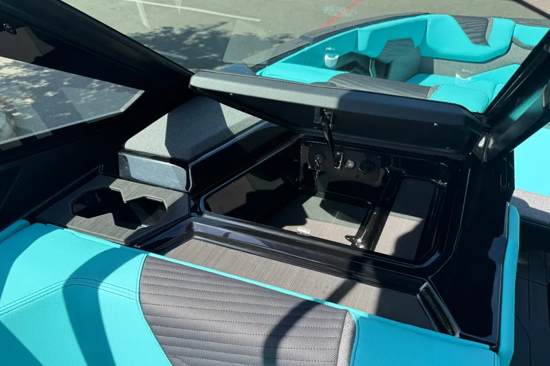 Slide: The Image of 2026 MasterCraft X24 boat interior with open storage compartment and teal seating. - 46