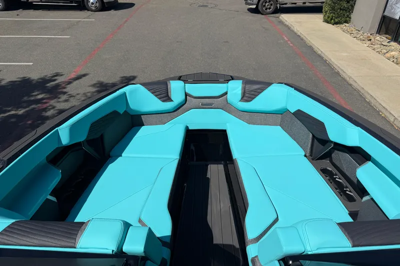 Slide: The Image of 2026 MasterCraft X24 boat with turquoise seating in a parking lot. - 49