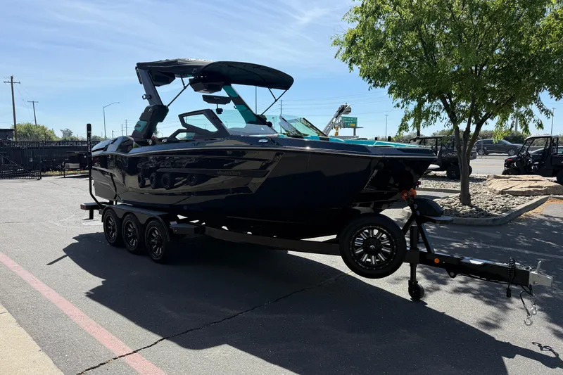 Slide: The Image of 2026 MasterCraft X24 boat on trailer in parking lot, sunny day. - 5