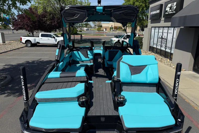 Slide: The Image of 2026 MasterCraft X24 boat with turquoise seating in a parking lot. - 72