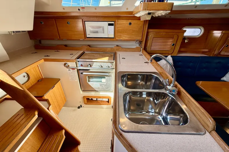 Slide: The Image of Interior of 2000 Catalina 36 MkII sailboat kitchen with wood cabinetry and dual sink. - 22