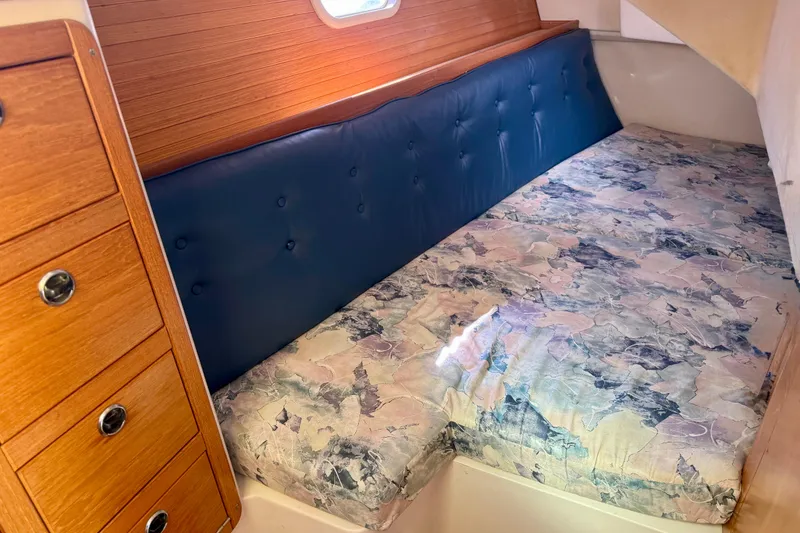 Slide: The Image of Cozy cabin interior of 2000 Catalina 36 MkII sailboat with patterned bedding and wooden cabinetry. - 23