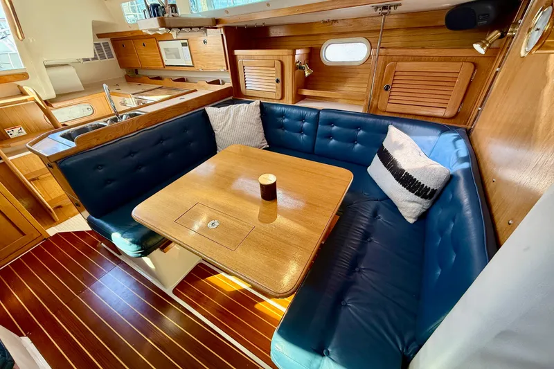 Slide: The Image of Interior of 2000 Catalina 36 MkII sailboat with cozy dining area and wooden finishes. - 26