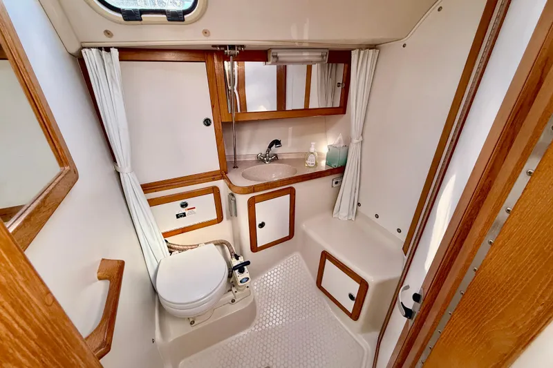 Slide: The Image of Bathroom interior of a 2000 Catalina 36 MkII sailboat, featuring wood accents and compact design. - 27