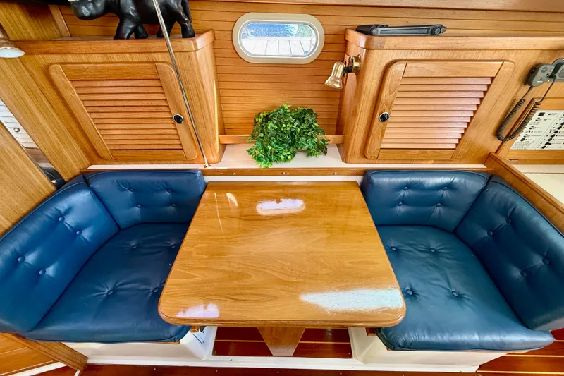 Slide: The Image of Interior of 2000 Catalina 36 MkII sailboat with blue cushioned seating and wooden table. - 31
