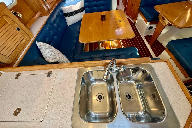 Slide: The Image of Interior of 2000 Catalina 36 MkII yacht with sink, table, and blue seating. - 33