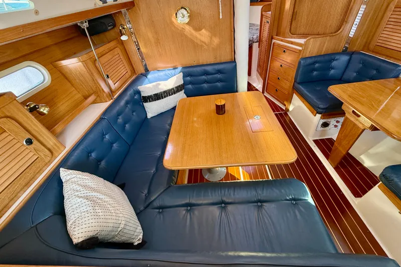 Slide: The Image of Cozy interior of 2000 Catalina 36 MkII sailboat with blue seating and wooden accents. - 34