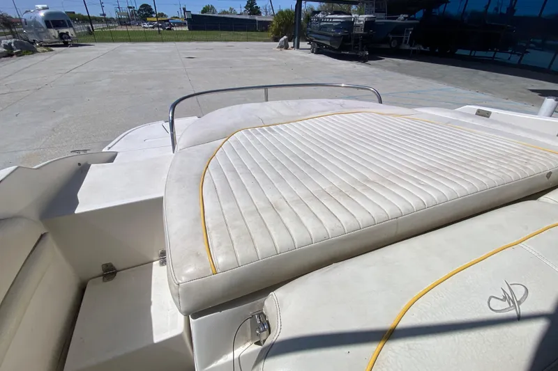Slide: The Image of 2003 Monterey 208SI Montura boat with white cushioned seating in a sunny outdoor setting. - 13