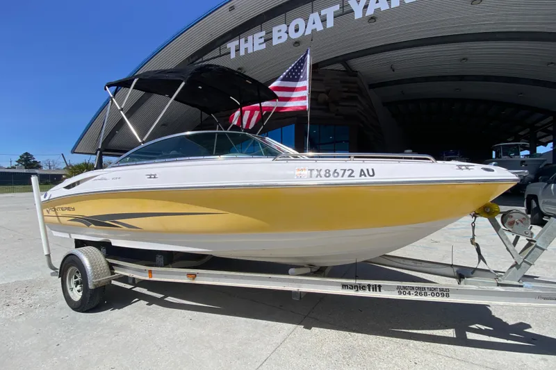 Slide: The Image of 2003 Monterey 208SI Montura boat on trailer at The Boat Yard, American flag visible. - 2
