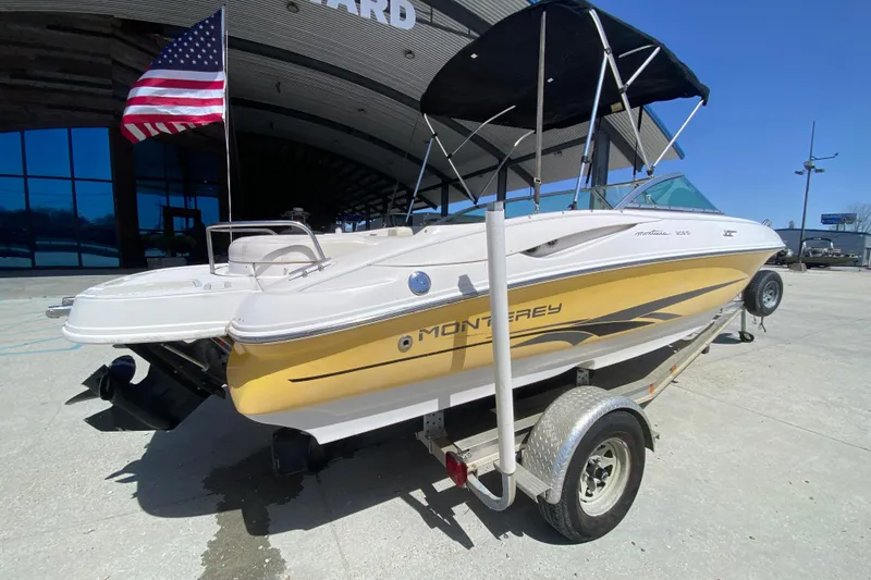 Slide: The Image of 2003 Monterey 208SI Montura boat on trailer with American flag, parked outdoors. - 4