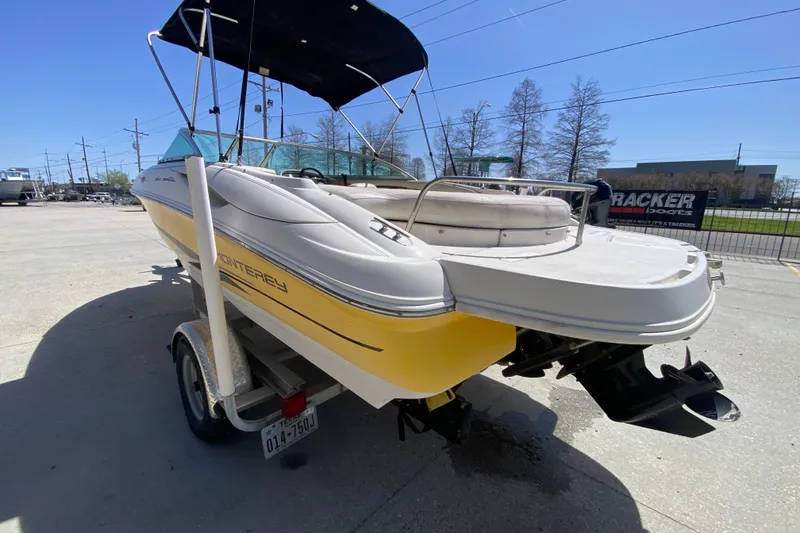 Slide: The Image of 2003 Monterey 208SI Montura boat on trailer, yellow and white, parked outdoors. - 6