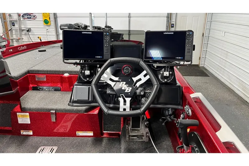 Slide: The Image of 2024 Bass Cat Puma STS boat dashboard with dual Lowrance displays and steering wheel. - 5