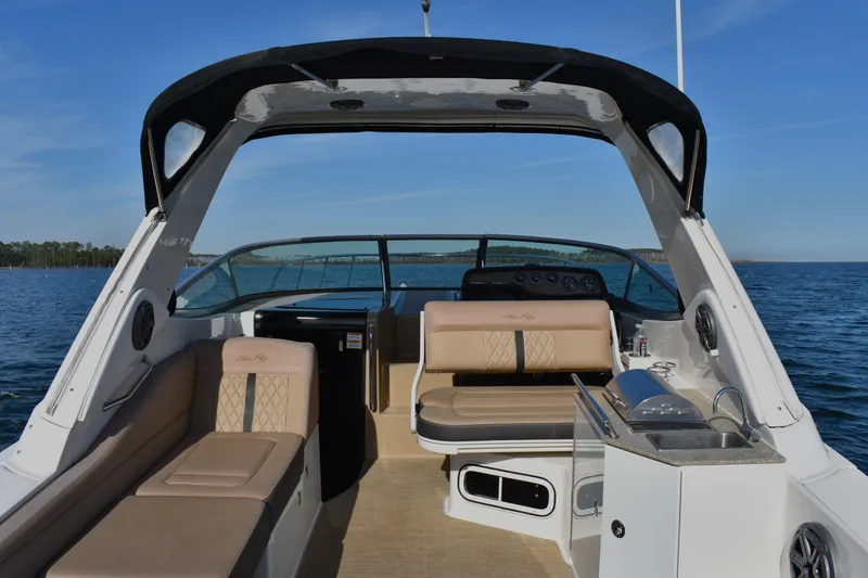 Slide: The Image of 2016 Sea Ray Sundancer 310 boat interior with seating and kitchenette on open water. - 11