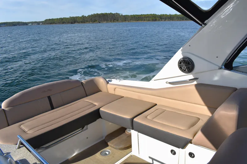 Slide: The Image of 2016 Sea Ray Sundancer 310 interior with beige seating, overlooking serene lake waters. - 17