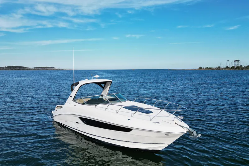 Slide: The Image of 2016 Sea Ray Sundancer 310 yacht on open water under clear blue sky. - 2