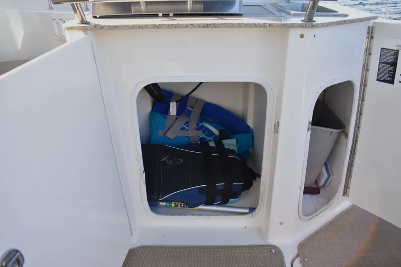 Slide: The Image of Storage compartment on a 2016 Sea Ray Sundancer 310 boat with life jackets and equipment. - 22