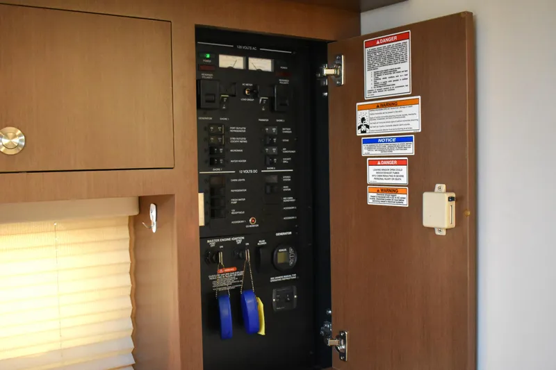 Slide: The Image of Electrical panel inside 2016 Sea Ray Sundancer 310 boat, featuring safety warnings and controls. - 25