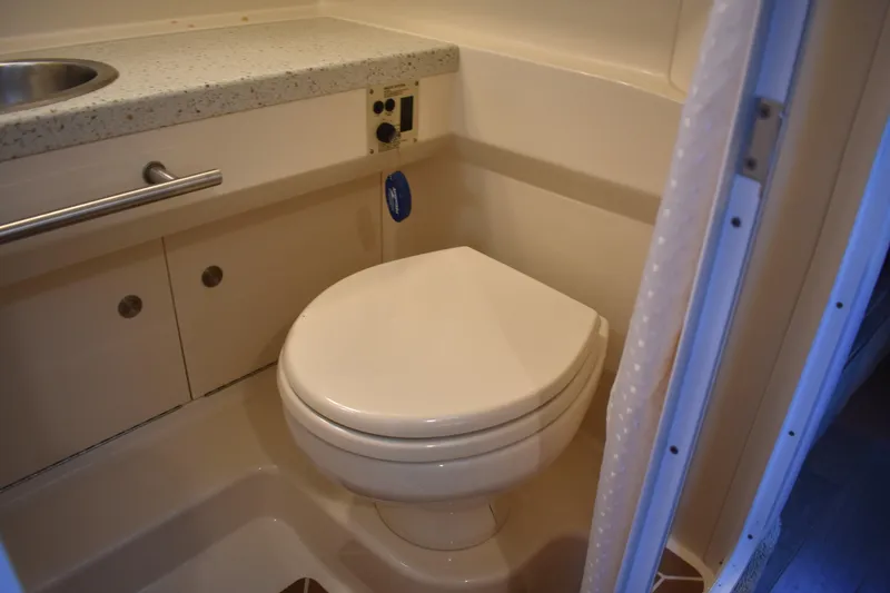Slide: The Image of 2016 Sea Ray Sundancer 310 bathroom with toilet and sink, featuring compact design. - 28