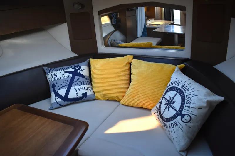 Slide: The Image of Interior of 2016 Sea Ray Sundancer 310 with cozy seating and decorative pillows. - 32
