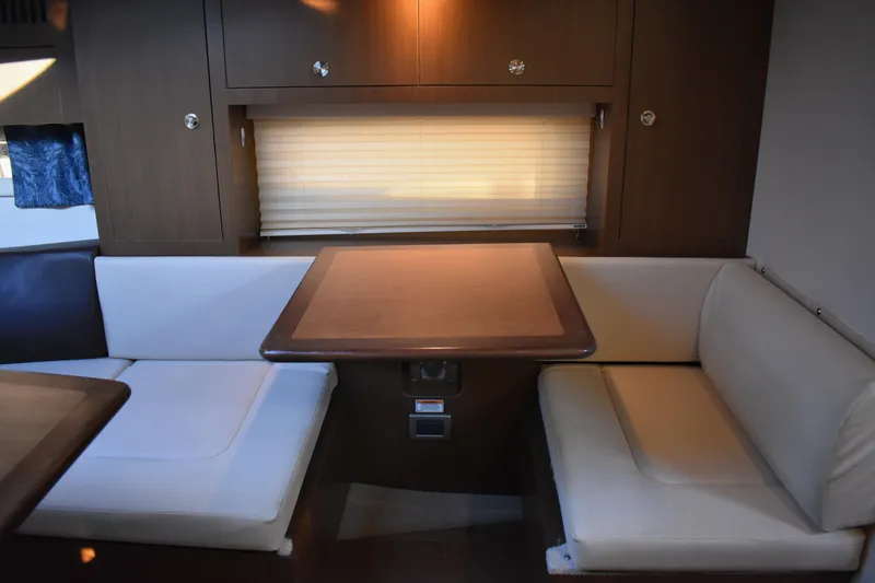 Slide: The Image of Interior of 2016 Sea Ray Sundancer 310, featuring a cozy dining area with cushioned seating. - 33