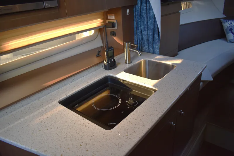 Slide: The Image of Modern kitchen area in a 2016 Sea Ray Sundancer 310 yacht, featuring a sleek countertop and appliances. - 36