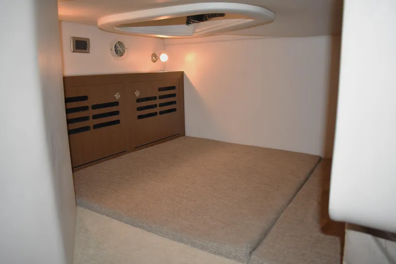 Slide: The Image of Interior cabin of 2016 Sea Ray Sundancer 310, featuring cozy carpeted flooring and ambient lighting. - 37