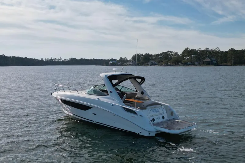 Slide: The Image of 2016 Sea Ray Sundancer 310 cruising on a serene lake under a clear sky. - 5