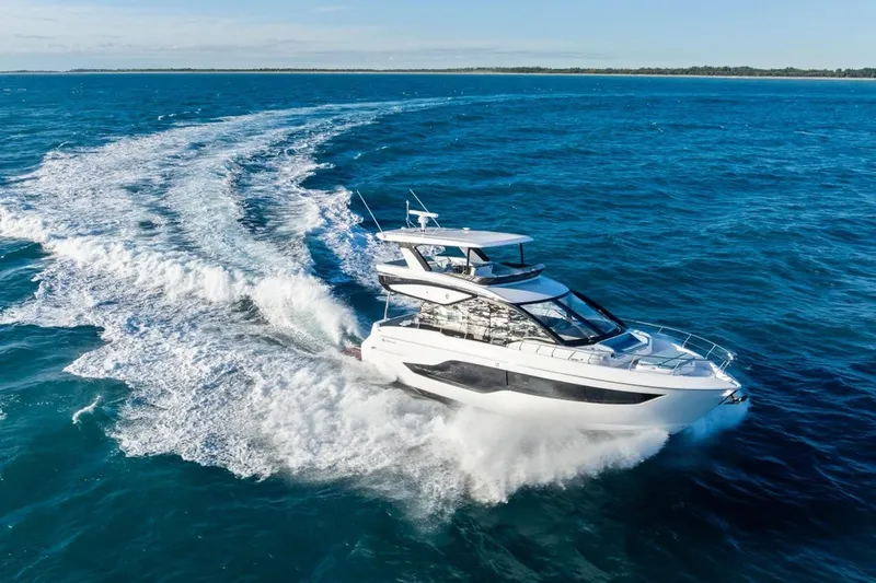 Slide: The Image of 2026 Cruisers Yachts 50 Fly cruising on open blue ocean waters. - 2