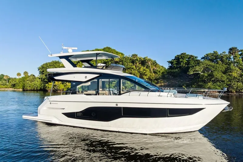 Slide: The Image of 2026 Cruisers Yachts 50 Fly on serene water, surrounded by lush greenery. - 29