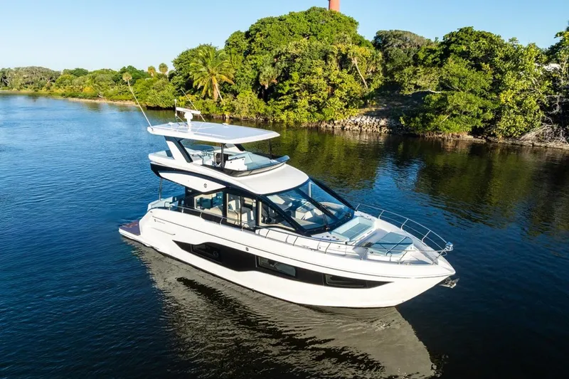 Slide: The Image of 2026 Cruisers Yachts 50 Fly on serene water, surrounded by lush greenery. - 30