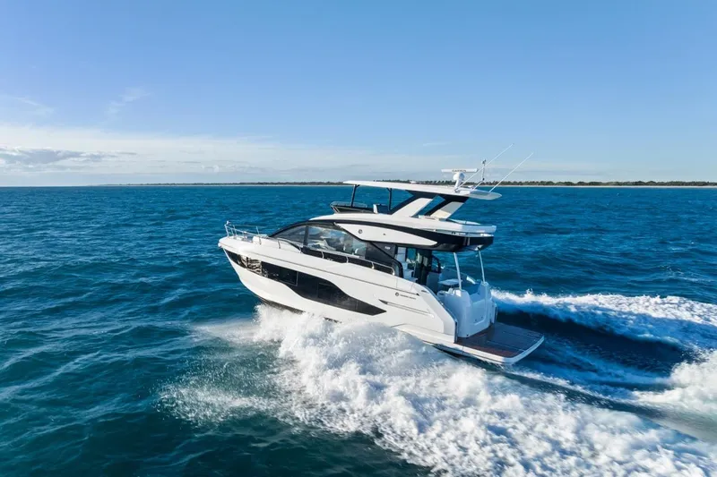 Slide: The Image of 2026 Cruisers Yachts 50 Fly navigating ocean waters under clear blue skies. - 34