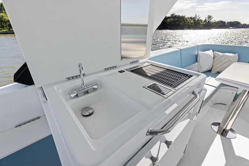Slide: The Image of Outdoor kitchen on 2026 Cruisers Yachts 50 Fly, featuring sink and grill. - 56