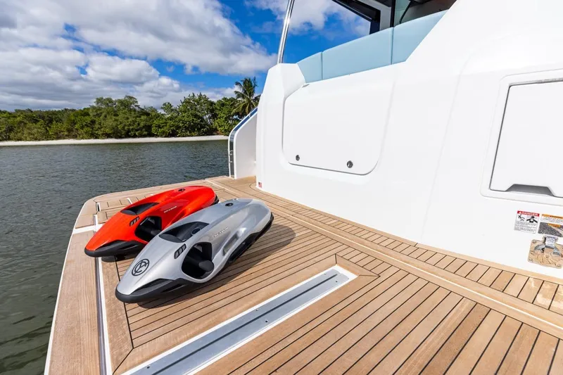 Slide: The Image of 2026 Cruisers Yachts 50 Fly deck with two sleek water scooters. - 83