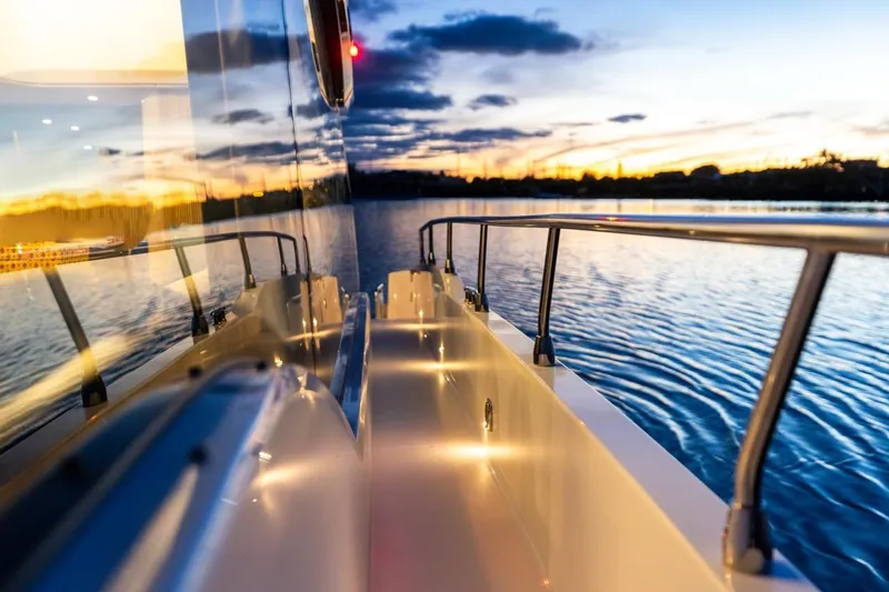 Slide: The Image of 2026 Cruisers Yachts 50 Fly reflecting sunset on calm waters. - 85