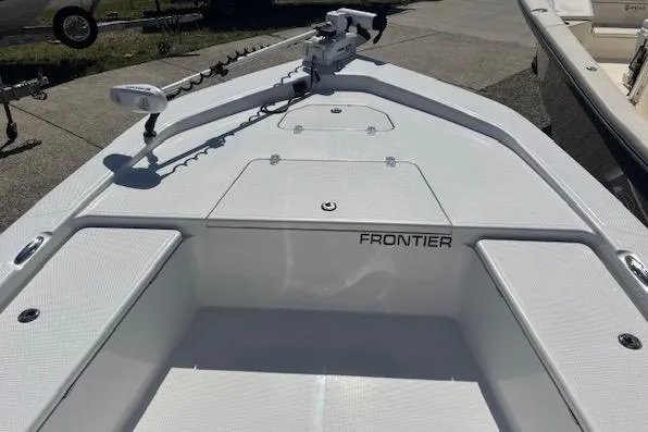 Slide: The Image of 2022 Frontier 2104 boat deck with trolling motor, white finish, outdoor setting. - 11