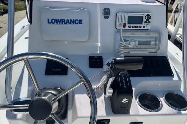 Slide: The Image of Boat dashboard with steering wheel, Lowrance equipment, and Suzuki controls on a 2022 Frontier 2104. - 8