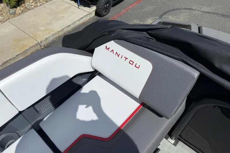 Slide: The Image of 2025 Manitou Cruise boat seat with logo, featuring sleek gray and white design. - 12