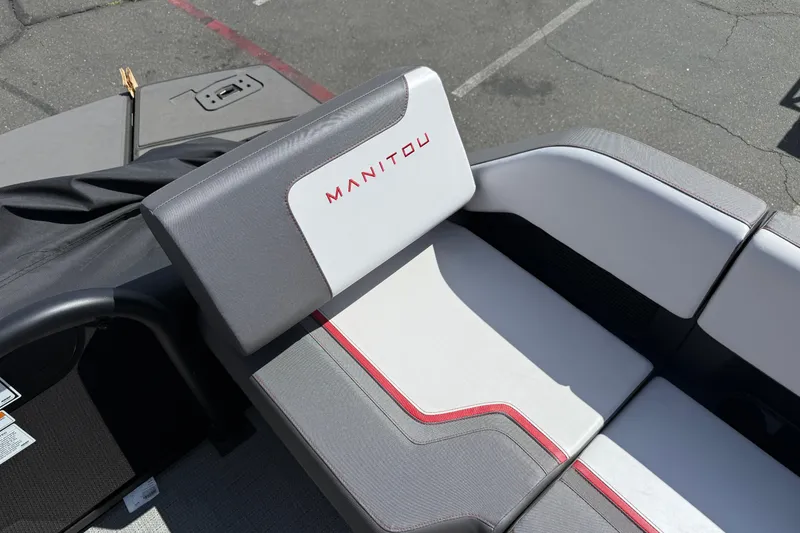 Slide: The Image of 2025 Manitou Cruise boat seat with gray and white upholstery, featuring red accents. - 13