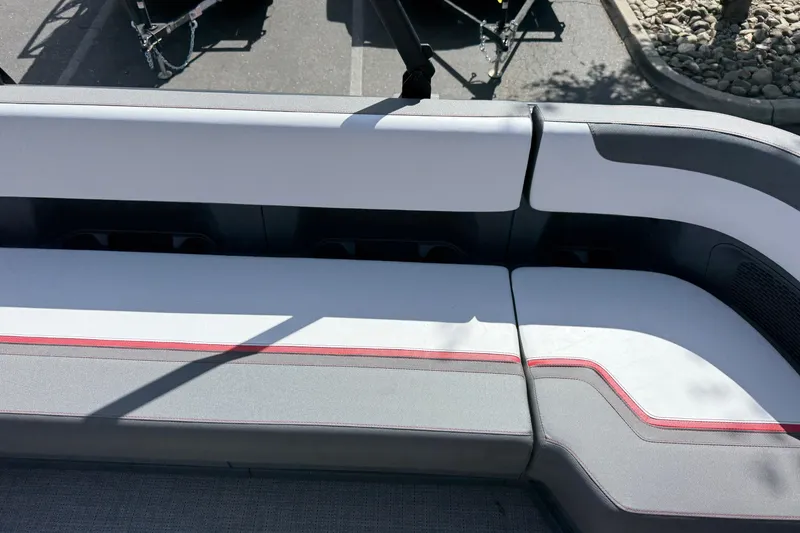 Slide: The Image of 2025 Manitou Cruise boat seating with gray and white upholstery, featuring red accents. - 18