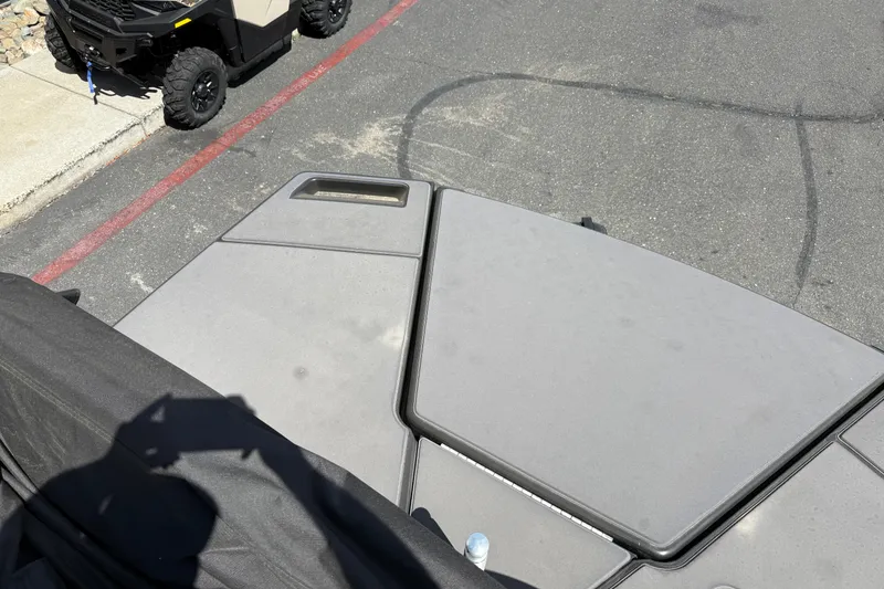 Slide: The Image of 2025 Manitou Cruise boat deck with shadow and parked vehicle nearby. - 23