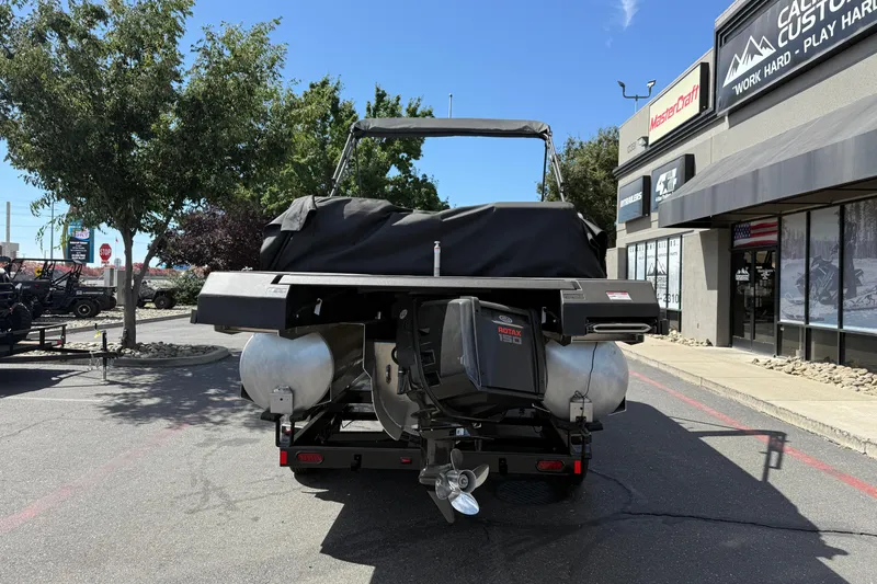 Slide: The Image of 2025 Manitou Cruise boat with Rotax engine, parked outside dealership on sunny day. - 4