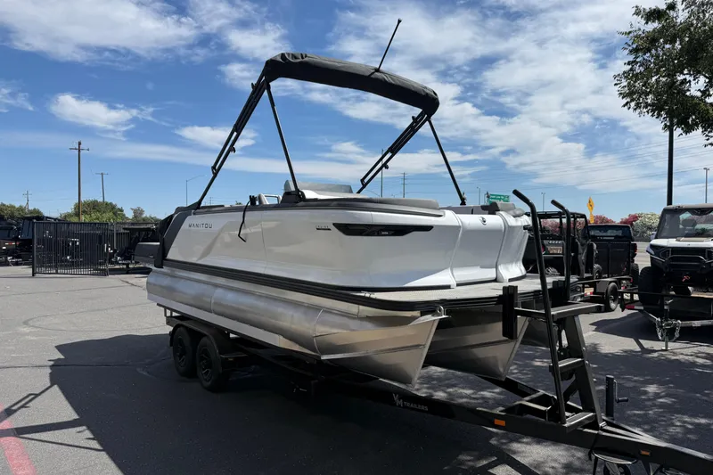 Slide: The Image of 2025 Manitou Cruise pontoon boat on trailer under clear sky. - 6