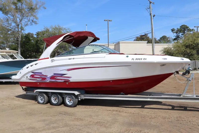 The Image of 2016 Chaparral 287 SSX boat on trailer, red and white design, parked outdoors. - 0